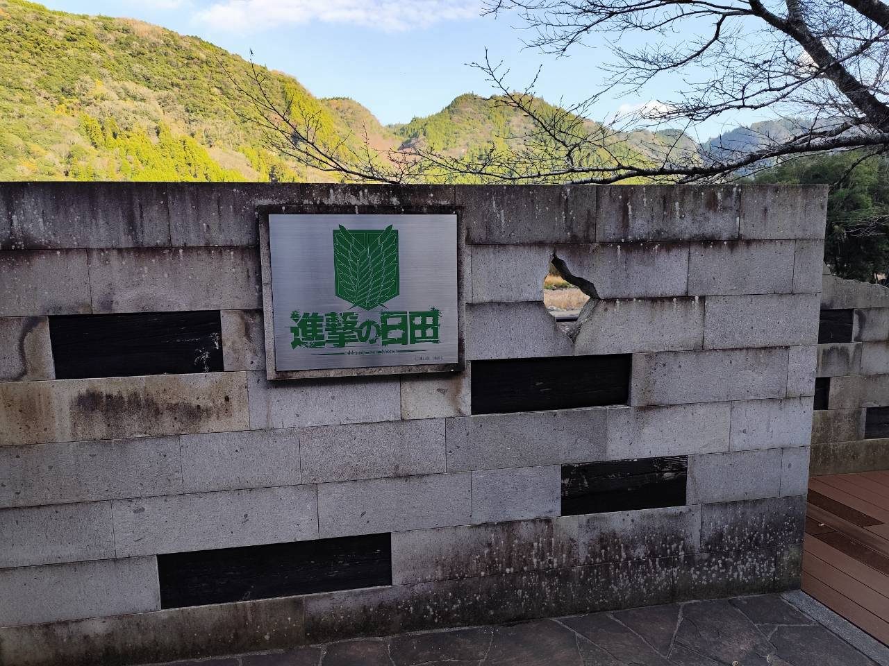 Stone wall with the Shingeki no Hita sign at the roadside station
